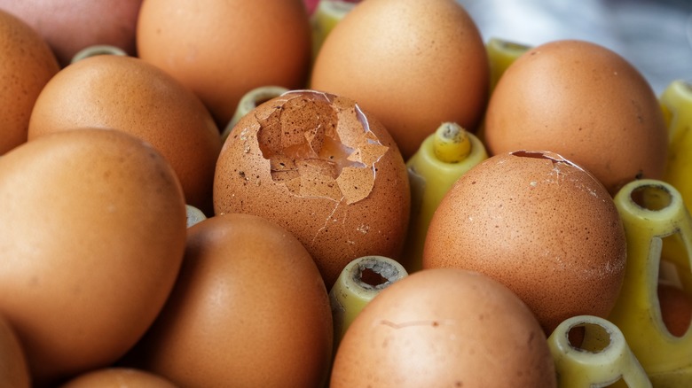 cracked eggs in carton