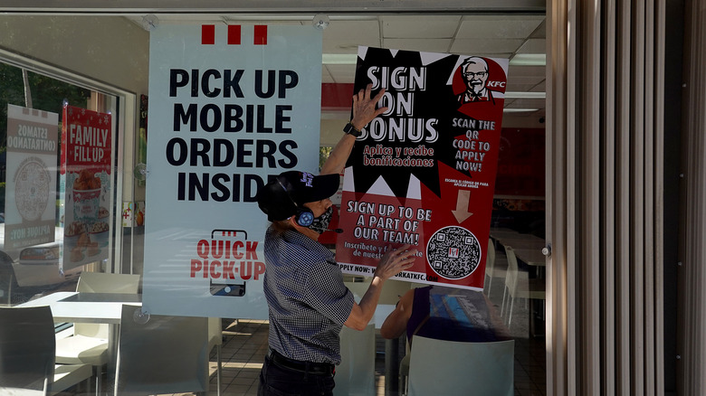 KFC employee hangs up signs