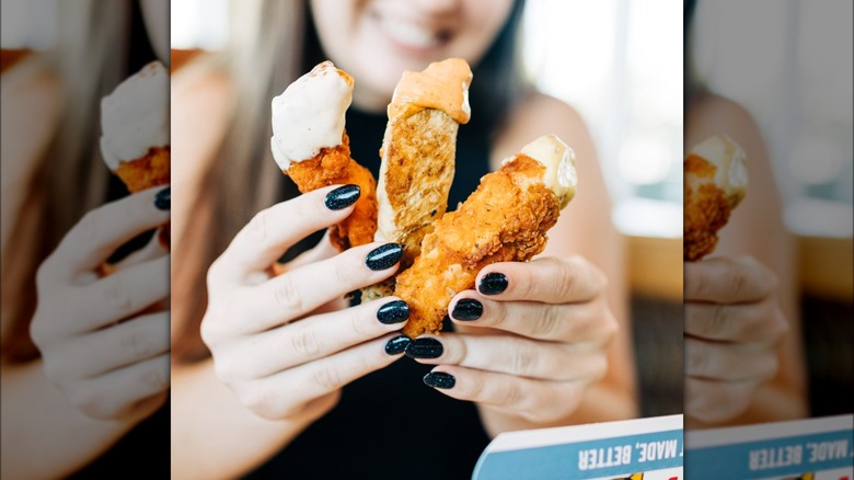 Hands holding chicken tenders