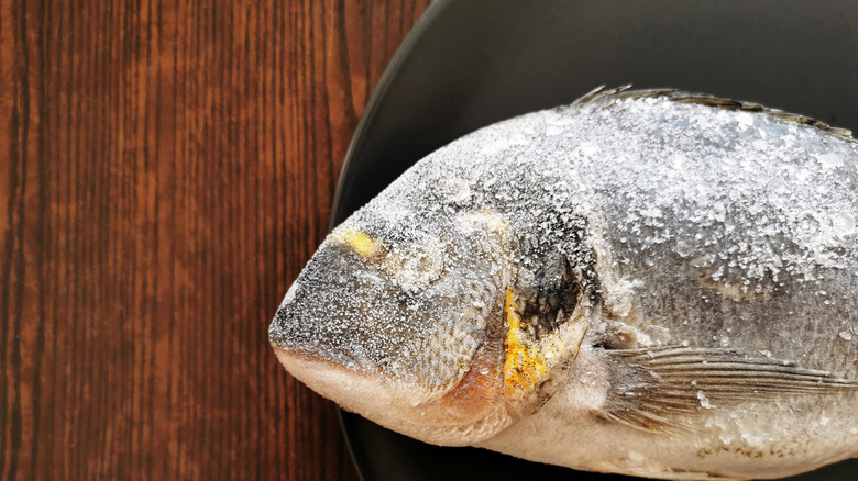 frozen fish on a board with freezer burn