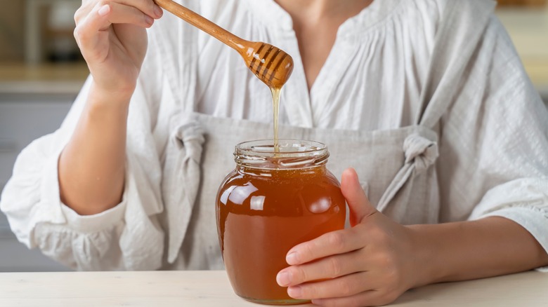 woman holding honey dipper 