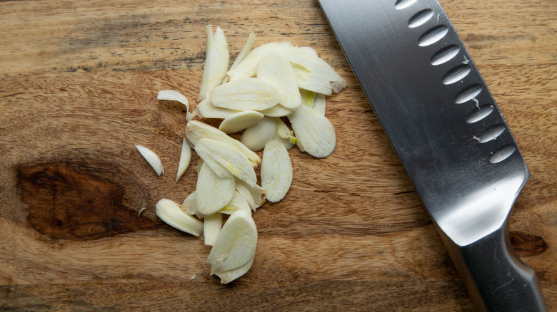 garlic slices on cutting board 