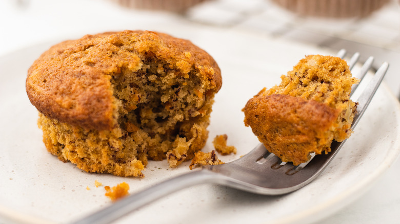 Banana carrot muffin on plate with bite taken out