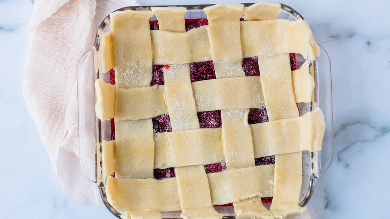 cobbler ready to bake with lattice pie topping in square baking dish