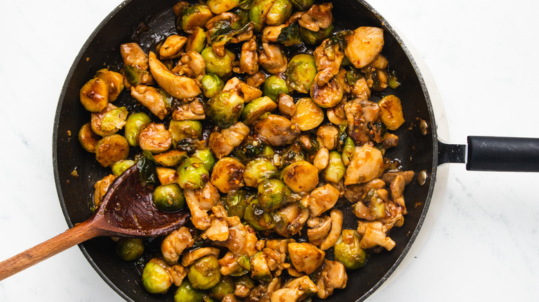 Chicken and Brussels sprouts stir fry in pan