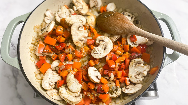 vegetable medley of mushrooms and peppers cooking in a pan