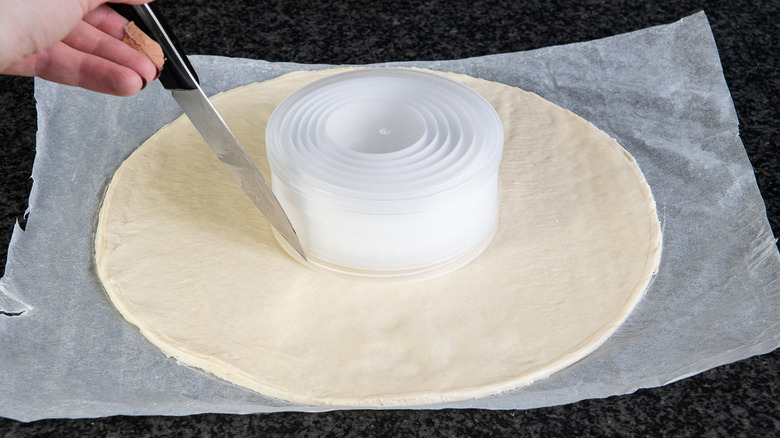 hand cutting pizza dough