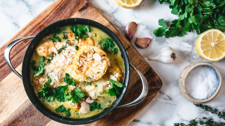 lemon chicken with herbs in a pot on a cutting board