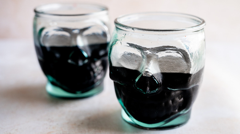 two black cocktails in glasses