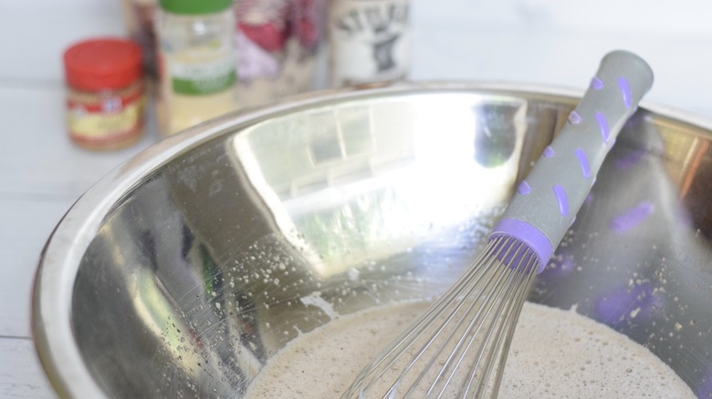 curing salt mixture whisked with water in stainless steel bowl