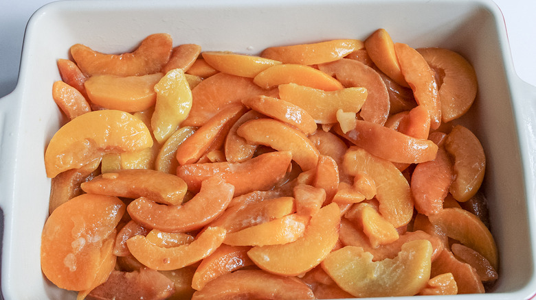 sliced peaches in baking dish