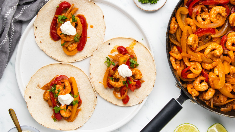 Shrimp fajitas on plate and in pan