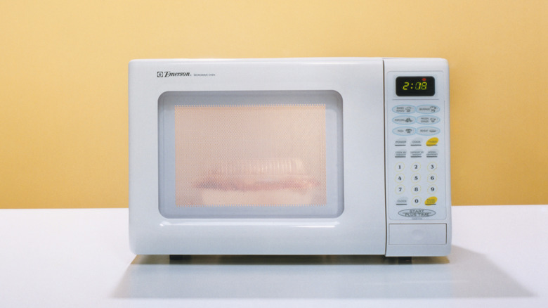 white microwave against yellow wall