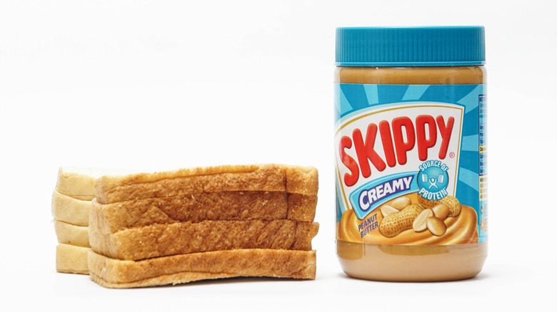 Skippy jar beside bread on white