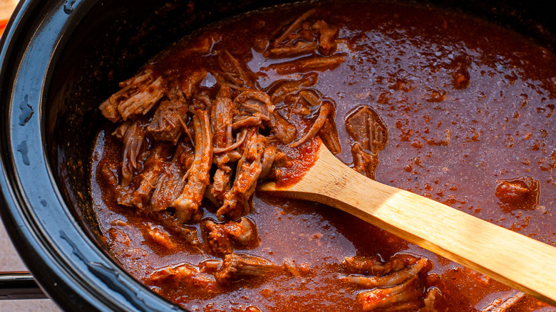 shredded pork on wooden spoon