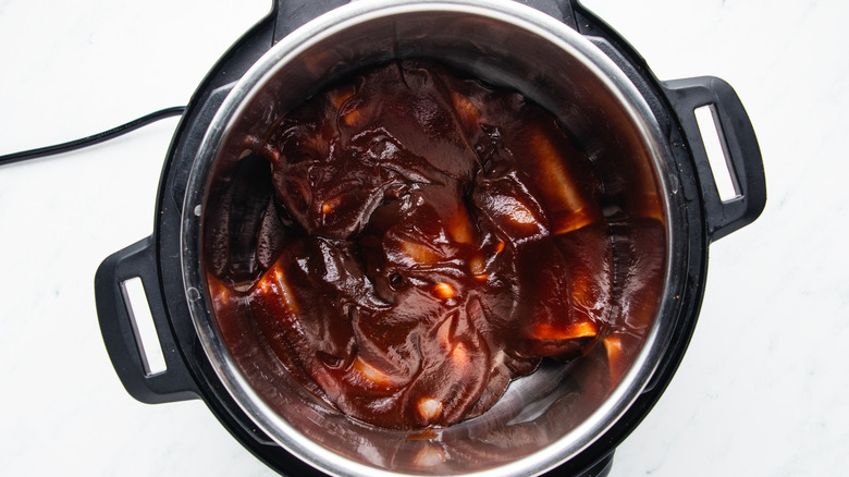 Barbecue sauce-covered chicken in slow cooker