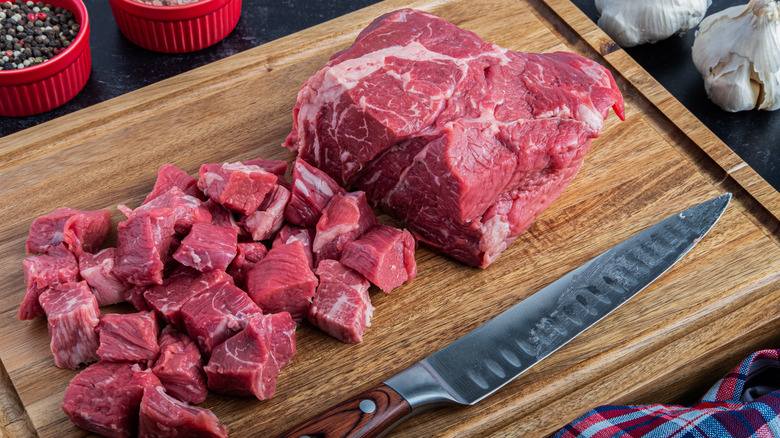 Cutting chuck roast on a wooden board