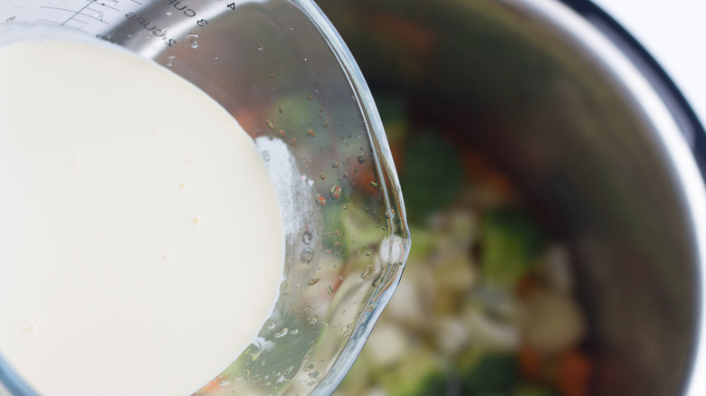 cream being poured into slow cooker