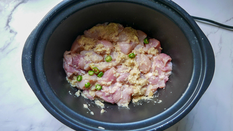 raw chicken for slow cooker curry with green chilies, onions, garlic