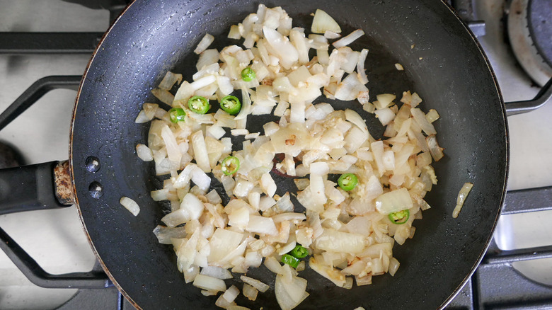 sauteed onions and sliced green chiles in pan