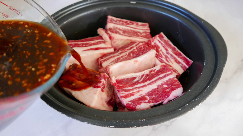 liquid pouring onto short ribs