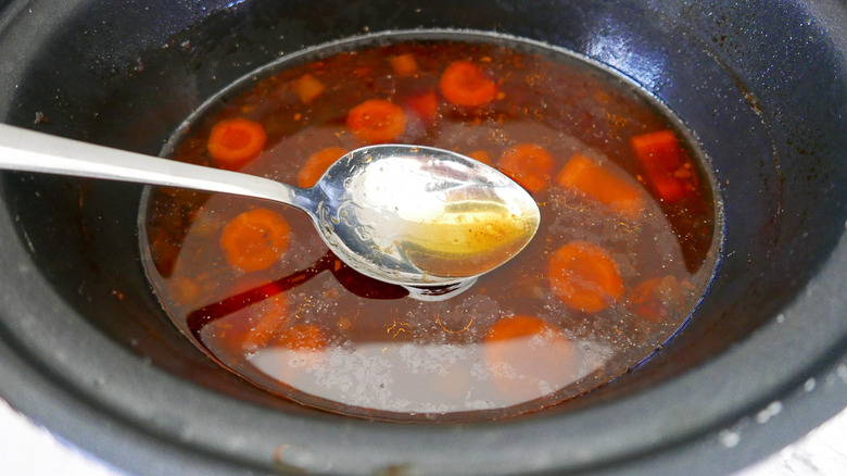 spoon and broth in slow cooker