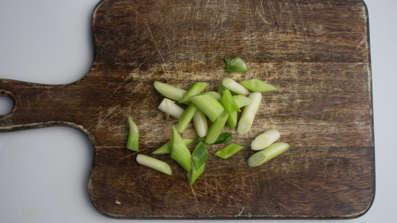 Chopped spring onions on cutting board