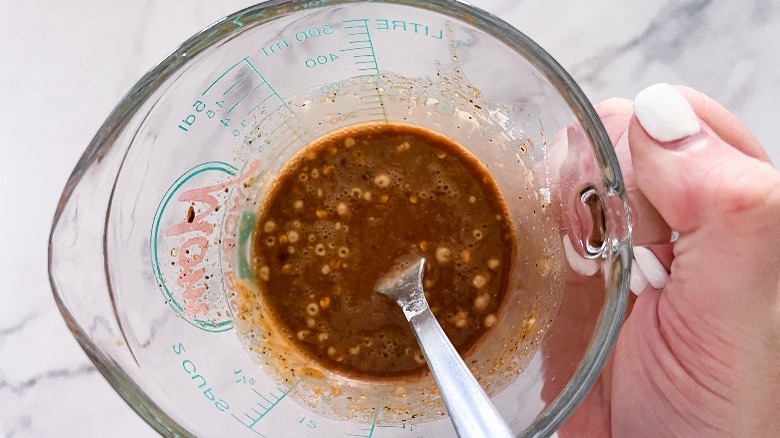 whisked sauce in measuring cup