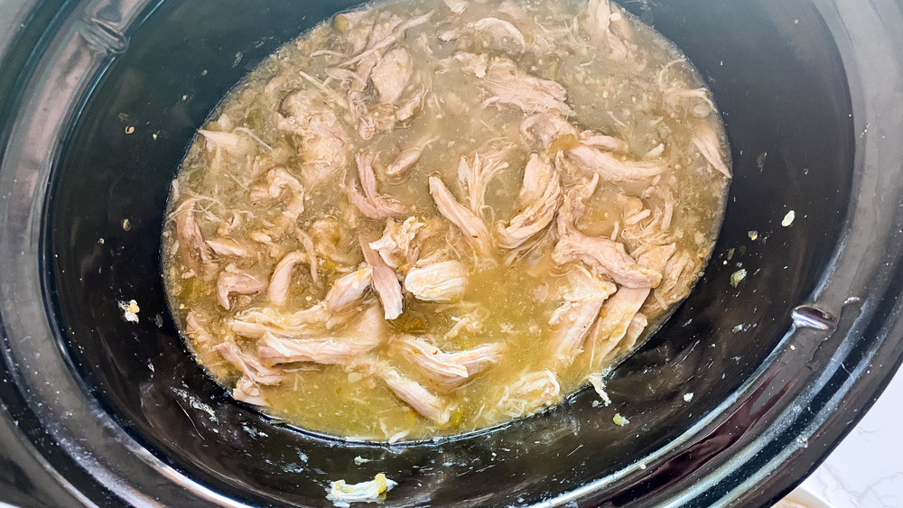 Shredded pork in a slow cooker for slow cooker pork green chili