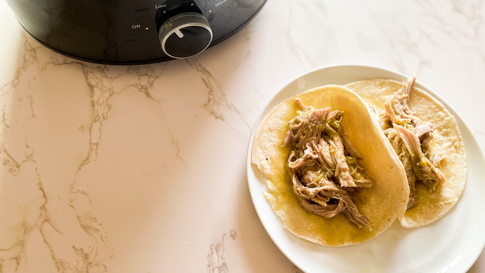 Slow cooker pork green chili served on tortillas on a plate