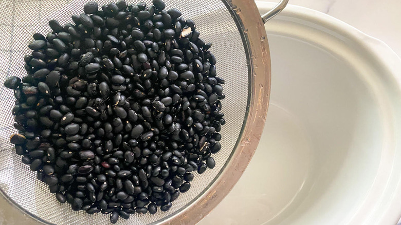 raw black beans in strainer