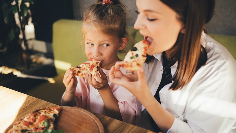 mom and daughter eating pizza