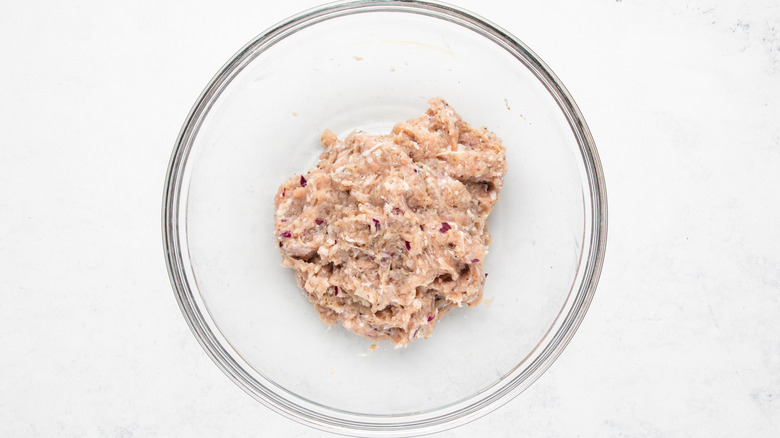 Seasoned ground chicken in mixing bowl