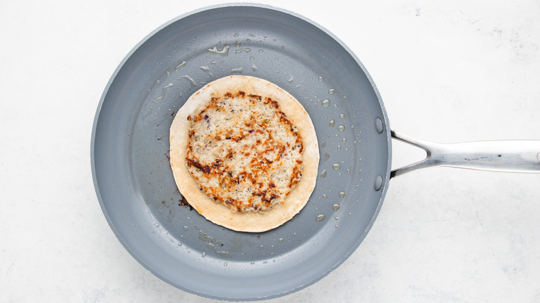 Smashed chicken gyro tortilla in frying pan