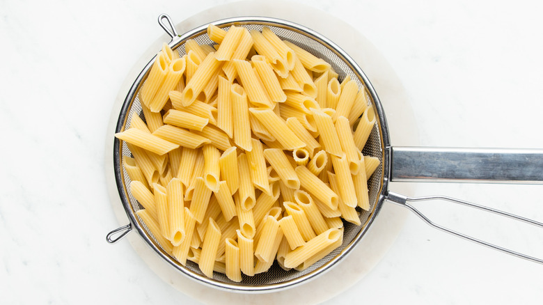 Cooked pasta draining in strainer