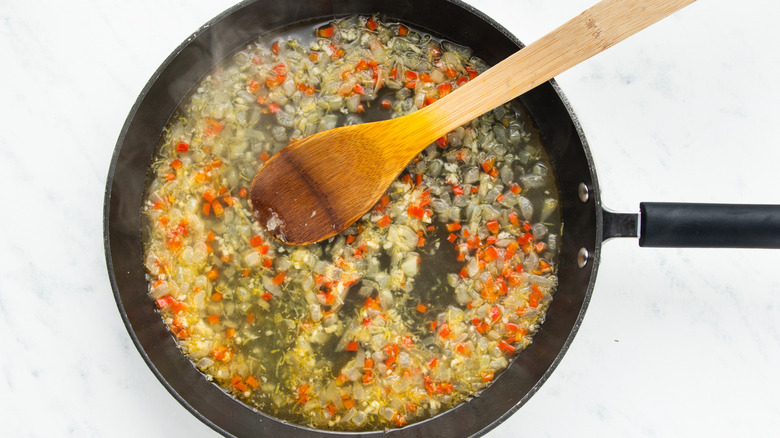 Onion, garlic, chili, lemon and pasta water in pan