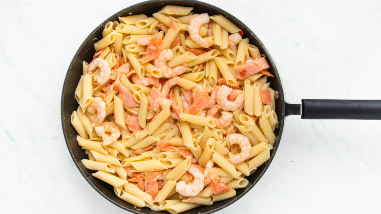 Salmon and shrimp pasta in pan