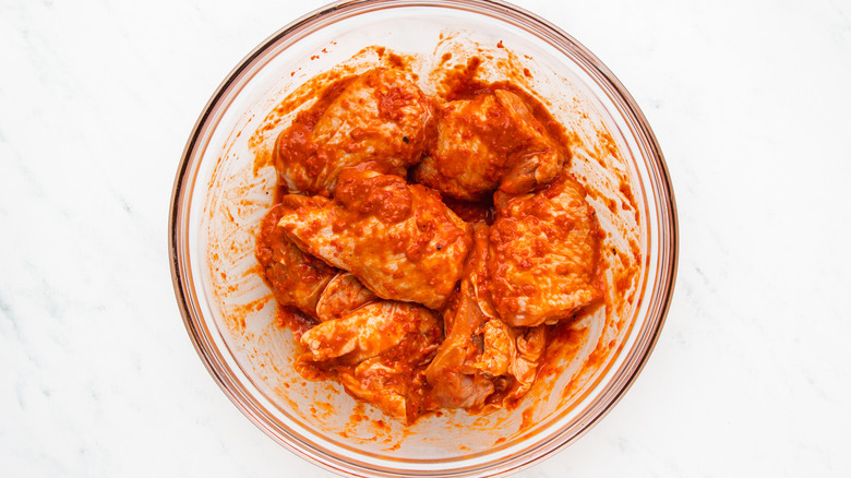 chicken marinating in mixing bowl