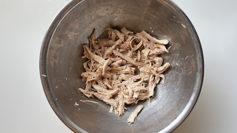 shredded chicken in metal bowl