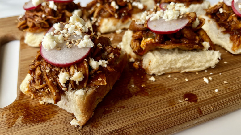 shredded chicken on bread rolls