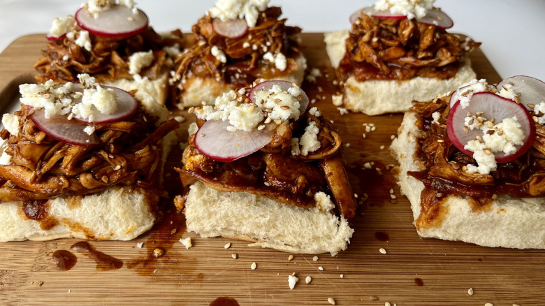 shredded chicken on bread rolls