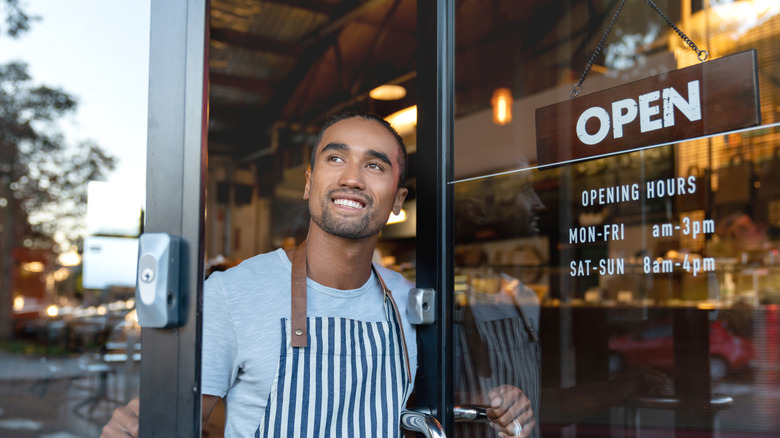 smiling waiter looking outside