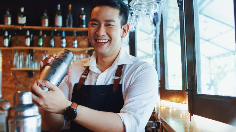 smiling bartender mixing a drink