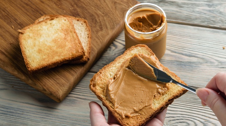 Spreading peanut butter on toast 