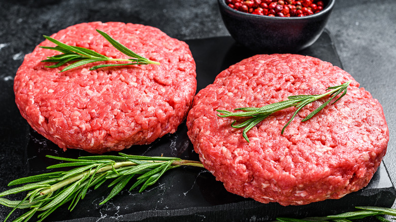 Raw hamburger patties with rosemary