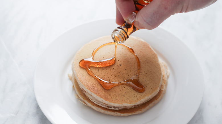 pouring syrup on snickerdoodle pancakes