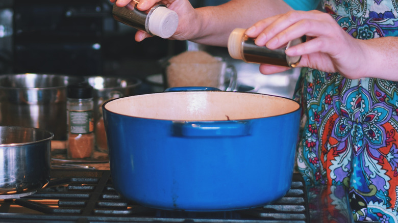 Cook putting seasoning into an older Dutch oven