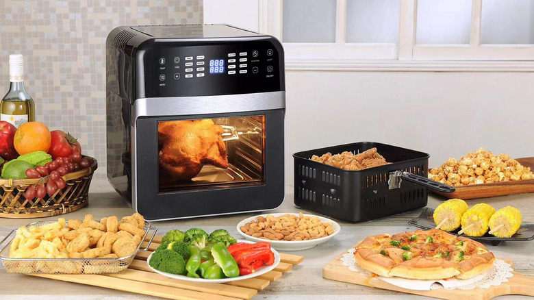 An air fryer surrounded by a variety of dishes