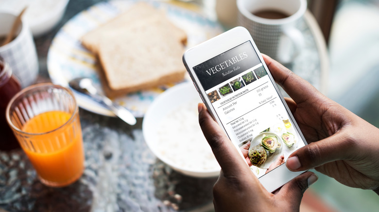 Person holding phone with recipe on screen