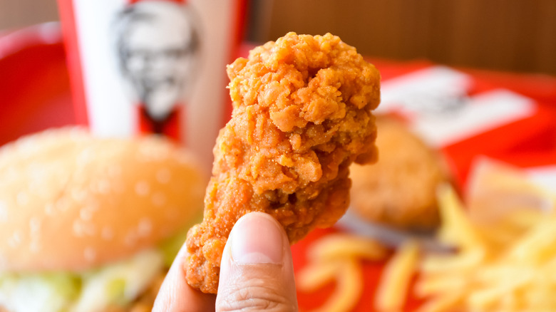 Fingers holding KFC chicken